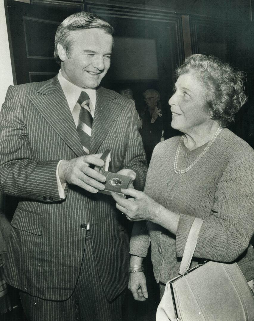 Premier William Davis chats with Mrs. Aglia Edwards, daughter of Toronto Symphony's first conductor, Luigi von Kunits. A gold medallion, commemorating(...)