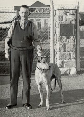 Watchdog to Guard Quints. The Dionne quintuplets may be forbidden by Dr. Alan Roy Dafoe to play with Tony, the dog shown here with Provincial Officer (...)