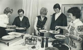 A hot buffet supper is served to guests by Marjorie Elwood, right, to mark a curling victory