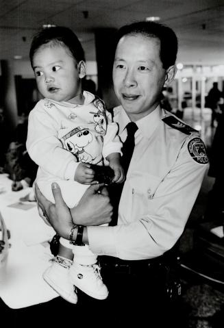 Help for Gordon: Police Sergeant Benjamin Eng attends a clinic yesterday and holds Gordon Wu, 18 months, afflicted with a rare blood disorder