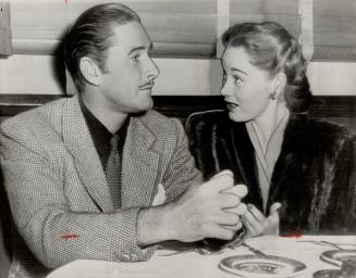 Dinner together is enjoyed, apparently, by Errol Flynn and his wife, Nora Eddington in a Holloywood cafe