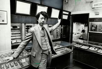 Double trouble: Jewelry storeowner Shing shows electronic eye he had put in after two daylight break-ins by armed robbers in six months