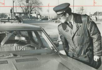 Bullet hole in Windshield of getaway car is examined by Constable Clement Quesnelle is Alderwood Plaza on Brown's Line