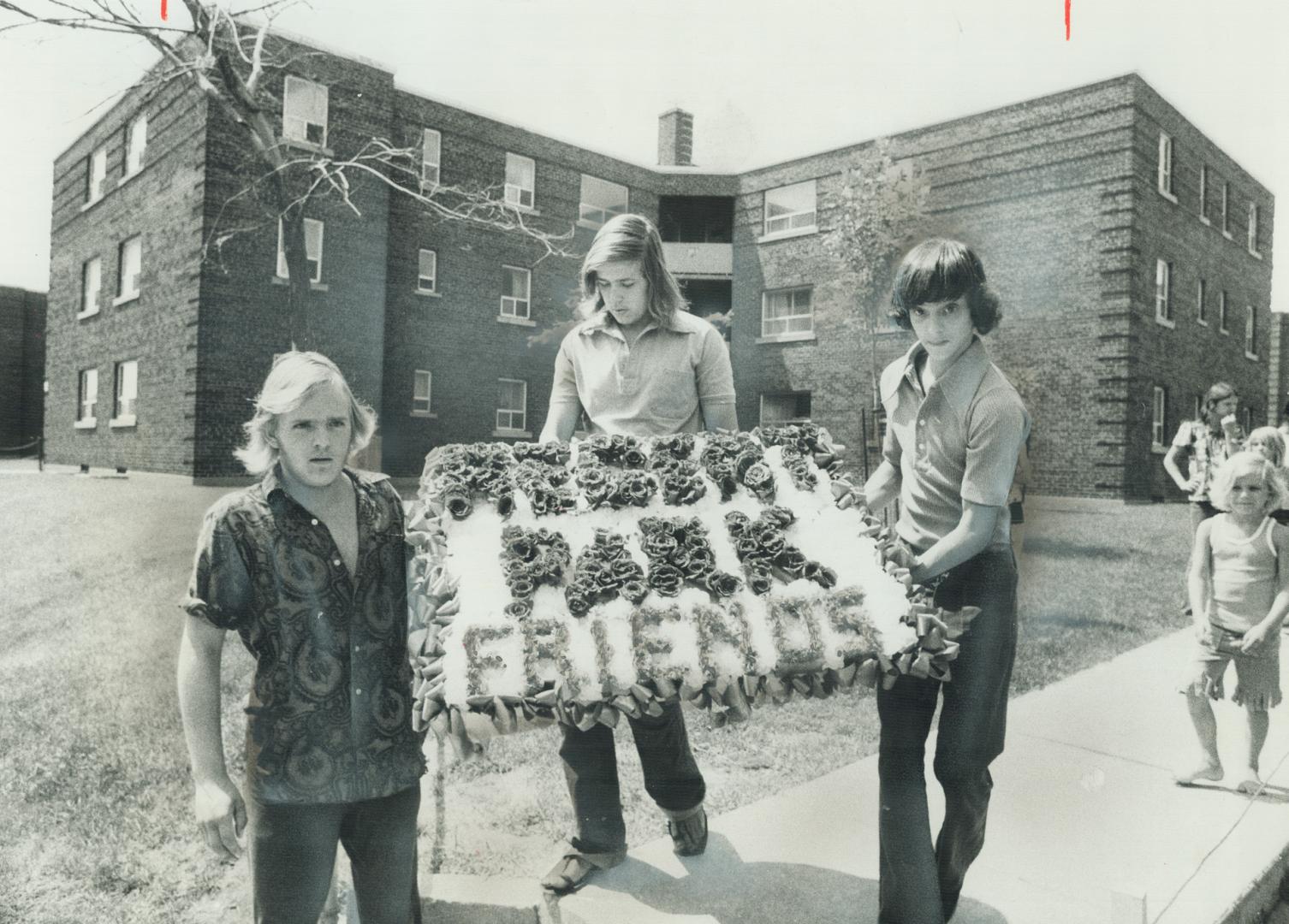 A $500 Wreath is held by the three boys who bought it for $81