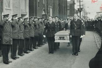 The Coffin of slain Constable Leslie Maitland is carried by fellow officers through a double line of saluting policemen