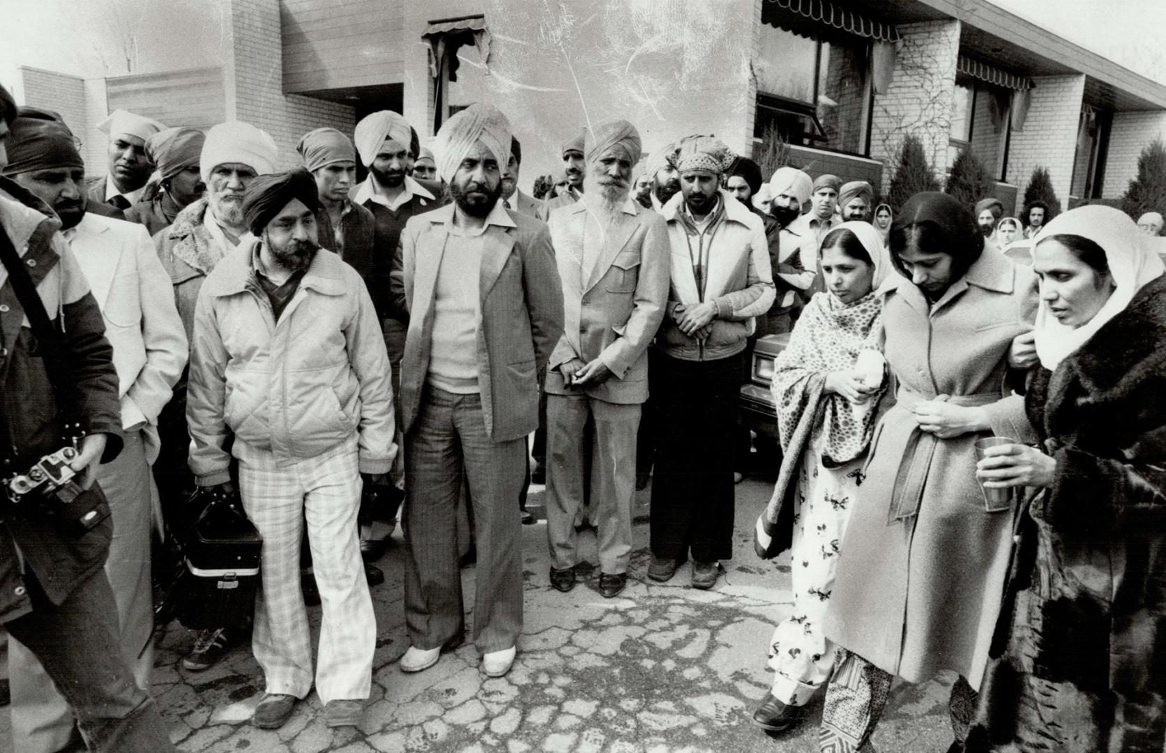 Mourning widow: Gurpal Kaur, 31, widow of Bhupinders Singh Pannu, is led into the Riverside Cemetery chapel yesterday by two women