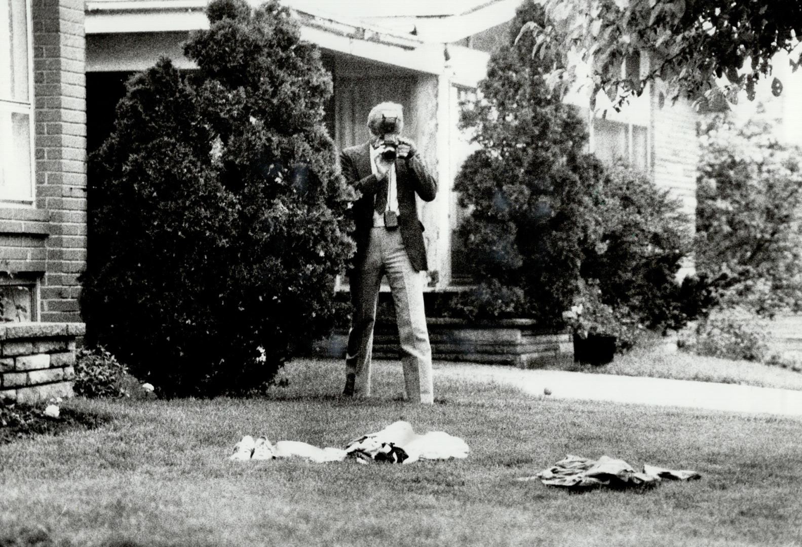 Looking for clues: Police take photographs at the murder scene in an attempt to find Jenny Isford's killer