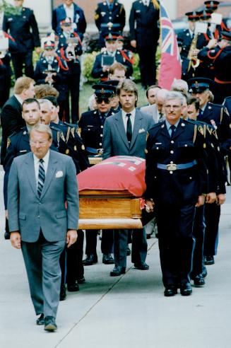 Painful Task: Pallbearers carry the coffin of Slain OPP Sergeant Thomas Cooper, draped with an Ontario flag presented by OPP Commissioner Thomas O'Grady