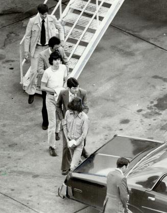 Diver, in front, and Gerow, in T-Shirt, are escorted off plane