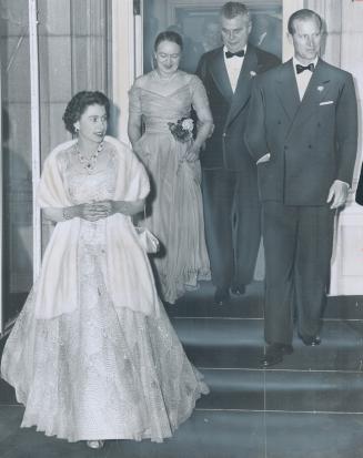 Prime Minister and Mrs. Diefenbaker accompany the Queen and Prince Philip to the door as they leave private dinner last night after staying an hour ov(...)
