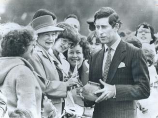 Prince Charles stops for a chat at the Victoria airport with a group of women who had presented him with a clay pot