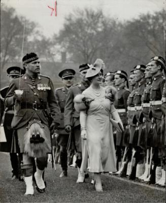 and below, her majesty, escorted by officers, inspects the kilted soldiers