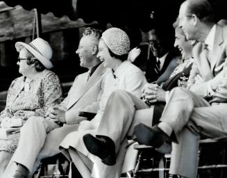 The mock bombardment of photographer has the Queen and Prince Philip laughing from under the canopy they shared with Jacob Froese (at her right), lord(...)
