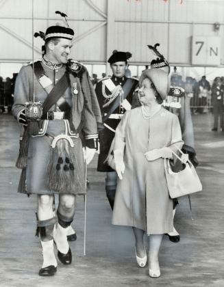 Towering Over the Queen Mother, Major Walter Goodsoe escorts her on her inspection of the Toronto Scottish Regiment, the guard of honor when she lande(...)