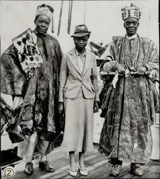 African delegates are seen in (2), the men wearing native dress, the girl using a smart western ensemble