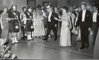 Arriving at the ball, Princess Margaret waves to crowd as she and Lord Snowdon cross the floor to the head table