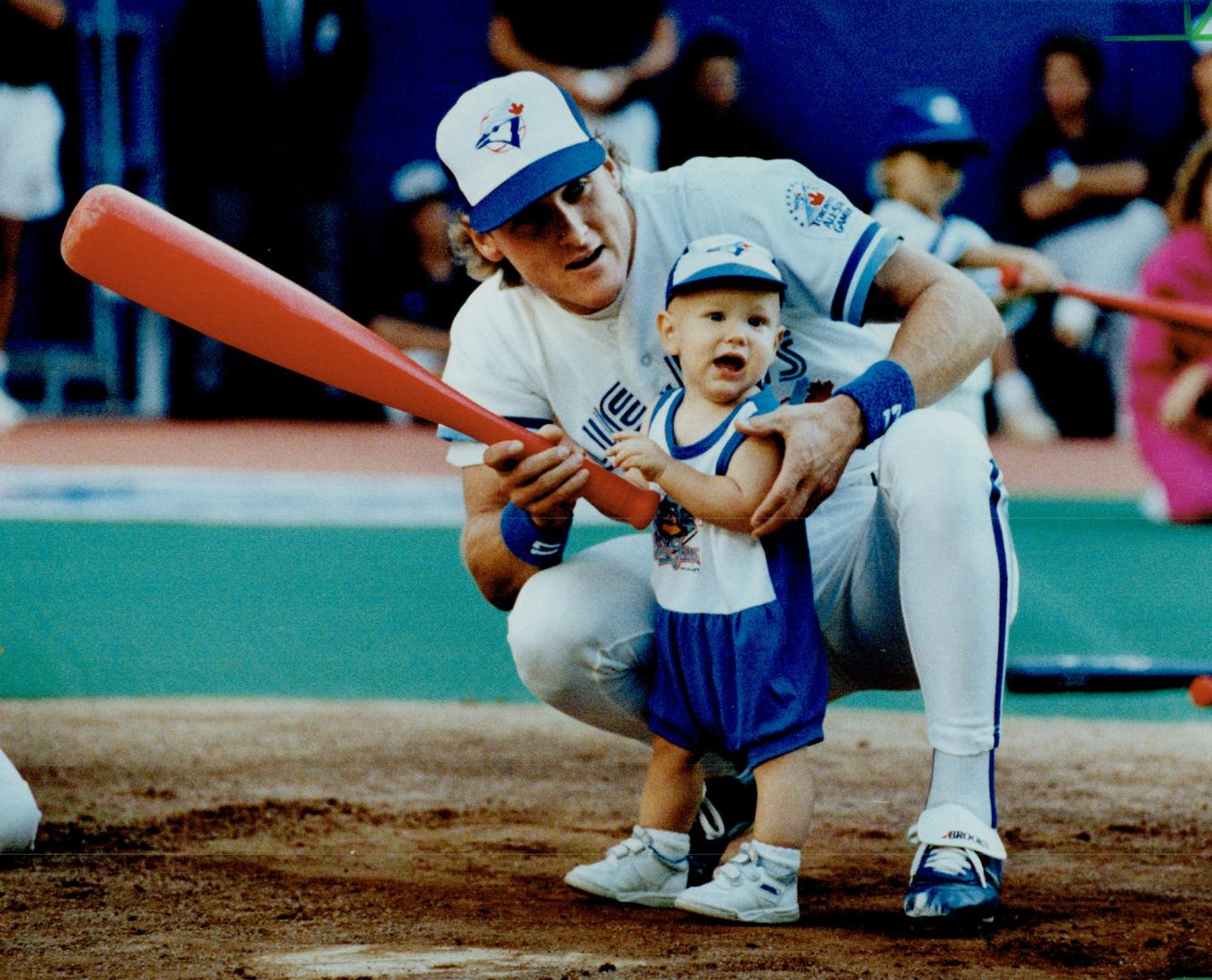 Blue Jays' third baseman Kelly Gruber gives his 1-year-old son, Kody, a few  hints on batting yesterday at the SkyDome, during a pre-game event for  the() – All Items – Digital Archive