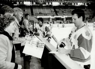 At right, the 1972 hero who scored the overtime goal to beat the Soviets in the eighth and final game, Paul Henderson joins in the autograph session. (...)