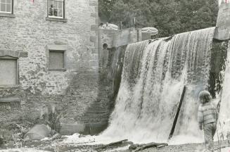 Watching the water go by, a young visitor to the Caledon Centre for the Arts and Crafts, Veda Neets, stands beside the 20 foot waterfall that tumbles beside the 90-year-old mill on the Credit River, near Alton.
