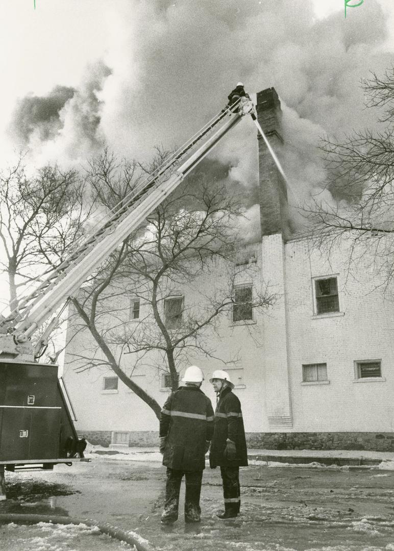 Hot finish: A fireman pours water into the blazing century-old building housing Freddie's Tavern, a Cambridge night spot featuring strip shows