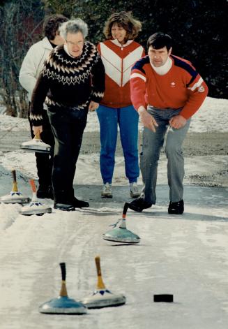 Having an ice day: Star columnist Frank Jones, left, tries his hand at the European game of ice stock sliding under the tutelage of Hans Schweighofer