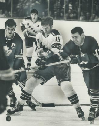 Breaking the barrier. Rangers' Jean Ratelle chops at sticks of Leaf trio barring way to puck during game at Gardens Saturday. Erecting roadblock are T(...)
