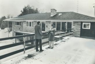 Katie King talks to one of her 'boys' in front of bungalow at Harold King Farm
