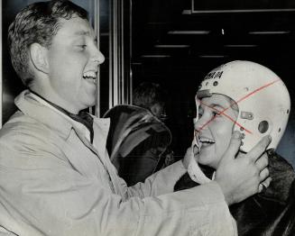 Bobsledder Mike Young lets sister, Shelagh, try on his helmet