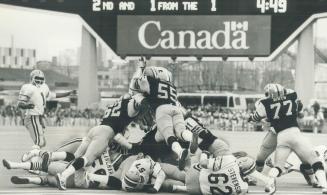 Hamilton's Carl Crennell (55) leaps high over pile of players in vain effort to stop Esks' Jim Germany from his one-yeard touchdown dive