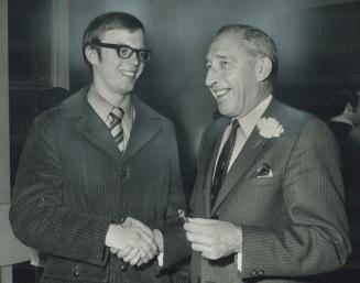 Richie Bayes, 21-year-old member of Canada's National Hockey team, is congratulated by Mississauga Mayor Robert Speck during a special awards night ho(...)