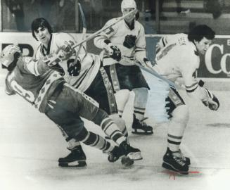 Vladimir Kovin (9) of the Soviet Union is knocked down by Team NHL defenceman Serge Savard