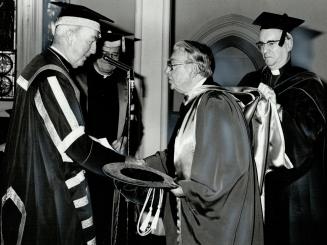 A degree of distinction: G. Emmett Cardinal Carter, chancellor of the University of St. Michael's College, confers the degree of Doctor of Letters upo(...)