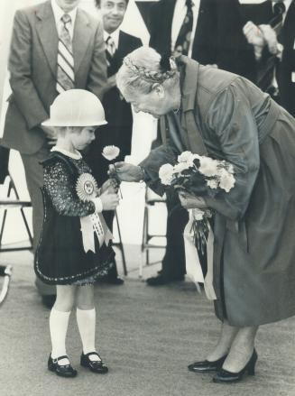 A flower from her bouquet is returned by Lieutenant-Governor Pauline McGibbon to Fiona Lower - complete with hard hat - after Fiona presented her with(...)