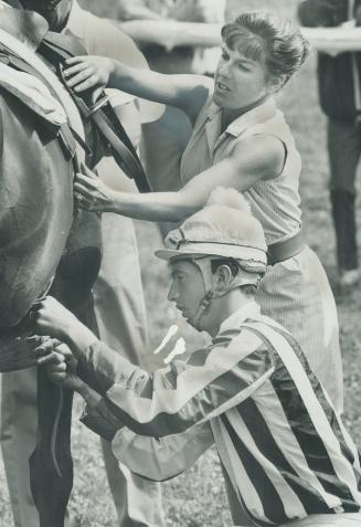 Sally Merrill, wife of trainer Frank Merrill and a conditioner in her own right, helps jockey, Earl Barnett, saddle Botticetto for Foxhunter Plate steeplechase race