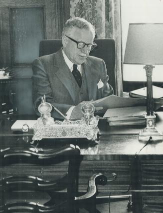 Governor-General Roland Michener at work in his oval, oak-panelled study