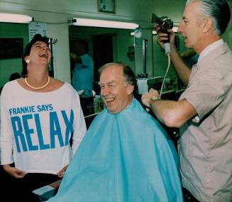 Ontario Premier Frank Miller has a laugh with 22-year-old Yolande Knol as he gets his hair cut by Danny Culos
