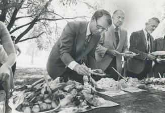 Liberal leader Rob Nixon helps himself to potato salad and cold roast chicken at a recent picnic lunch