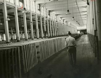 Father of eight, Rene Beauregard walks down empty aisle of the mill, lined with machines crated to go to the Philippines