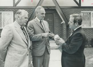 Mississauga Reeve Lou Parsons (right) gets the first of the new metric water meters from Art Kennedy, manager of Public Utilities Commission