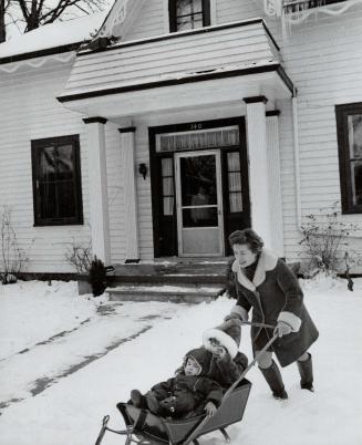 Left, Mrs. Patterson and the children play in the snow in fornt of the 102-year-old Stratford house which they are renovating. It was once a farmhouse owned by grandfather