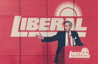 In the red, Wearing his trademark red tie and standing against the backd'op of his party logo, Premier David Peterson puts 1,800 Liberal party members(...)