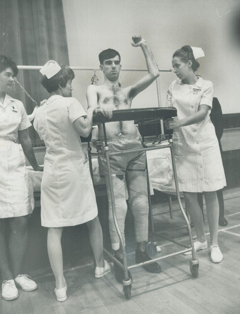 Making Medical history, Bertram Proulx, 24, is aided by two nurses as he stands beside wheeled walker