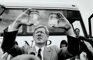 Murky mystery, New Democrat leader Bob Rae peers at samples collected by Newcastle-area farmers who fear a landfill site is slowly poisoning their water supply