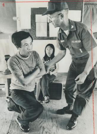 Begging for help in finding his wife and two of his children, Vietnamese refugee Tran Nhat Duong fell to his knees before Col. Ray Beery at Eglin Air (...)