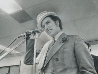 Prime Minister Pierre Trudeau dons straw boater during rally at Hamilton