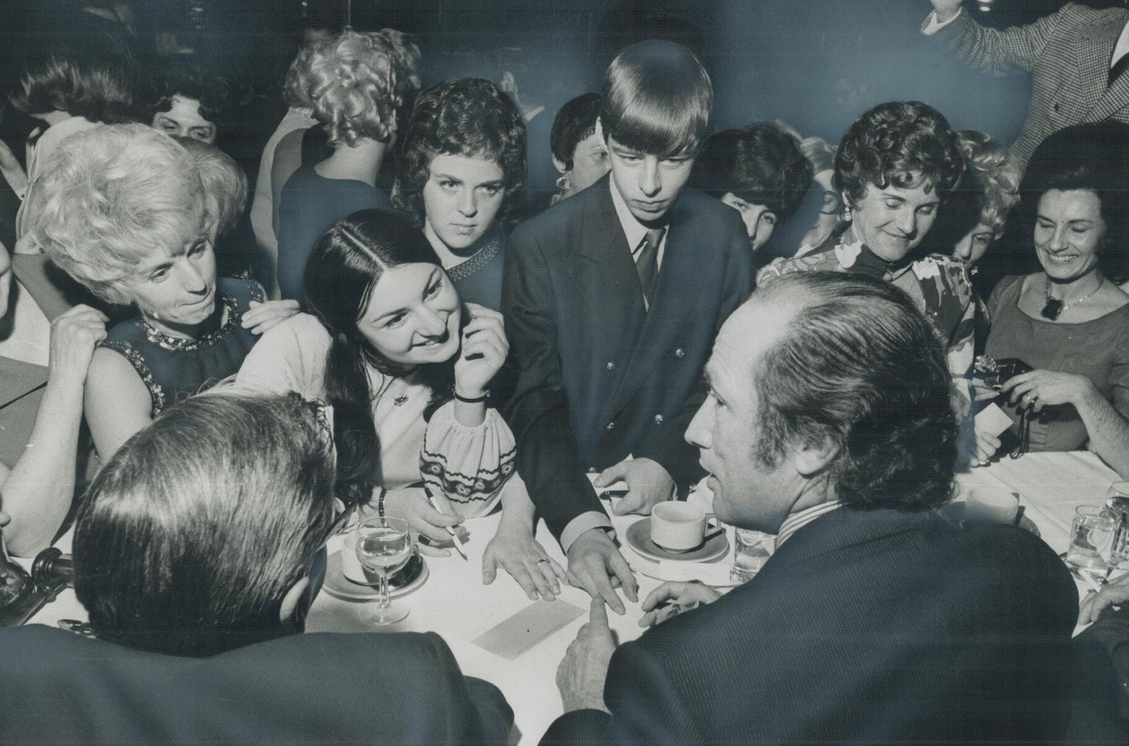 Autograph hunters crowd in tightly around table of Prime Minister Pierre Trudeau last night at Chamber of Commerce banquet in Niagara Falls