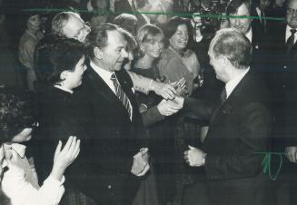 All hands on deck: Murray Koffler (left), chairman of Shoppers Drug Mart, has received his handshake from Prime Minister Pierre Trudeau, but other dinner guests mob him to try their luck