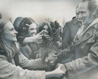 Waiting High School girls reach out to touch Prime Minister Pierre Trudeau, and present him with a bouquet as he arrives in Petrolia, Ont., yesterday (...)