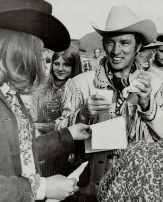 Taking time out for a snack, Prime Minister Pierre Trudeau eats a hamburger while attending a rodeo and barbeque at Williams Lake, B.C., on the last leg of his six-day western tour
