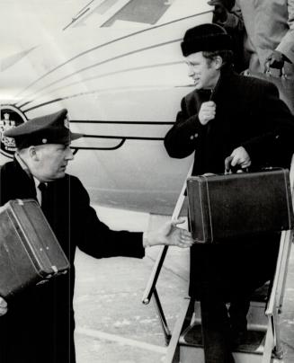 Prime Minister Pierre Trudeau returns yesterday to Montreal International Airport, wearing a fur coat and cap against temperature that hovered around zero